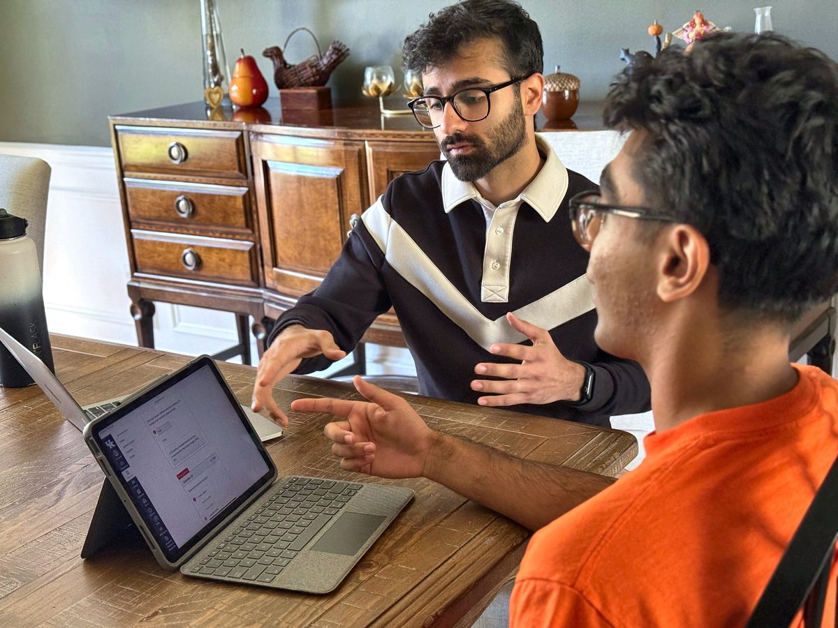 Saugat Bohara coaching a student at a dining table, talking through an assignment on a tablet